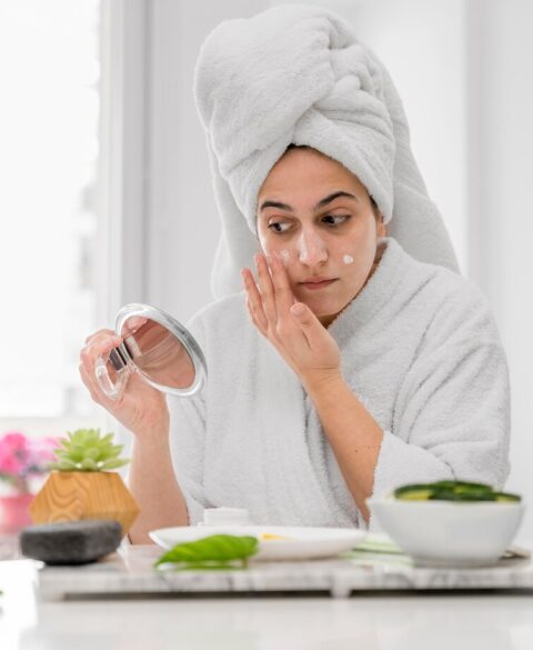 front-view-woman-applying-face-cream_23-2148708051