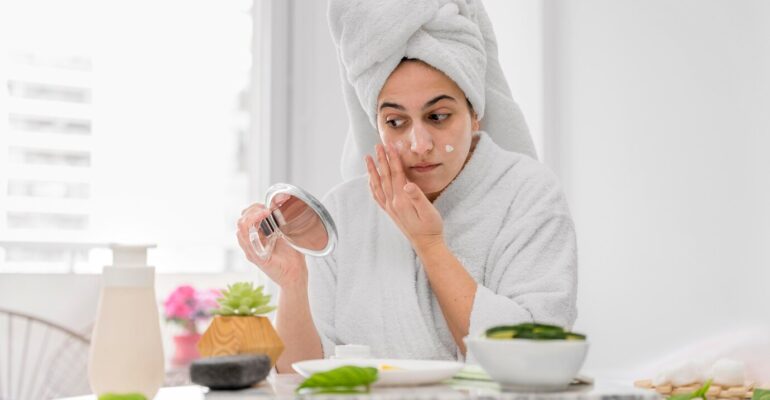 front-view-woman-applying-face-cream_23-2148708051